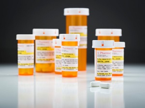 Medicine Bottles and Pills on Reflective Surface With Grey Background